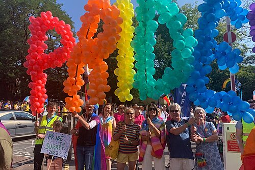 Surrey Lib Dems holding balloons spelling Pride