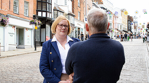 Zöe Franklin listening to a resident on Guildford High Street